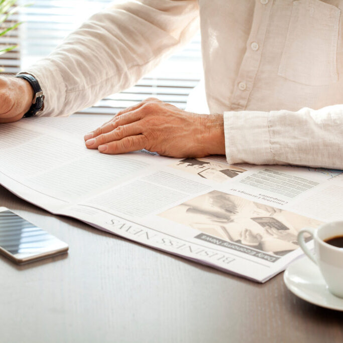 Man reading newspaper on table